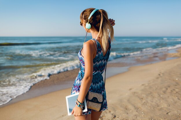 해변에서 음악을 듣고 예쁜 여행자 여자