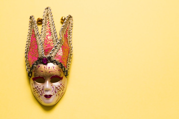 Free photo pretty venetian mask on yellow