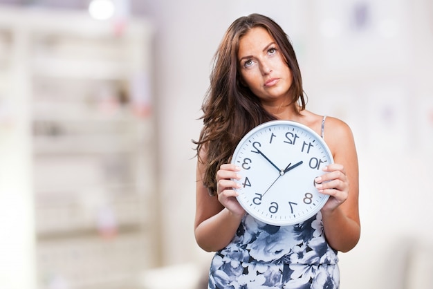 pretty woman angry holding a clock