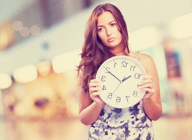 pretty woman angry holding a clock