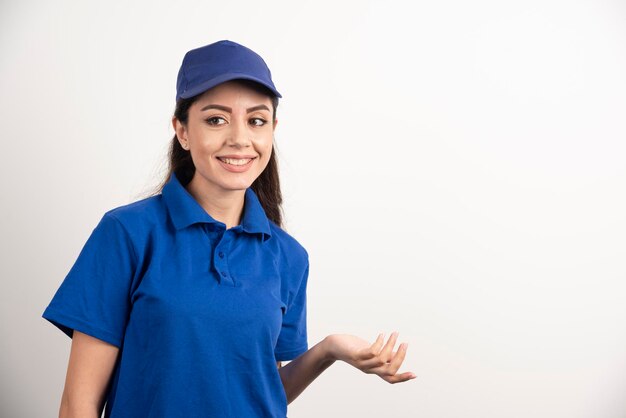 Pretty woman in blue uniform touch her face with hand. High quality photo