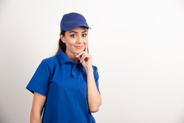 Pretty woman in blue uniform touch her face with hand. High quality photo