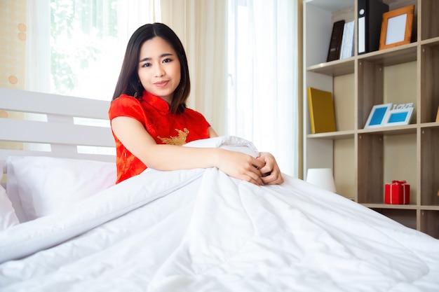 Красивая женщина в китайском платье в спальне