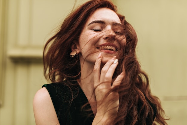 Pretty woman in dark green top smiling outside