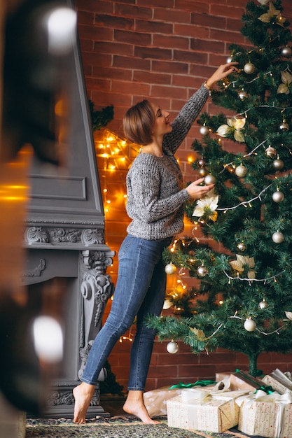 Free photo pretty woman decorating christmas tree