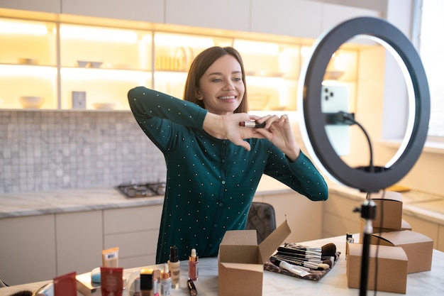 Pretty woman demonstrating new cosmetics and looking involved