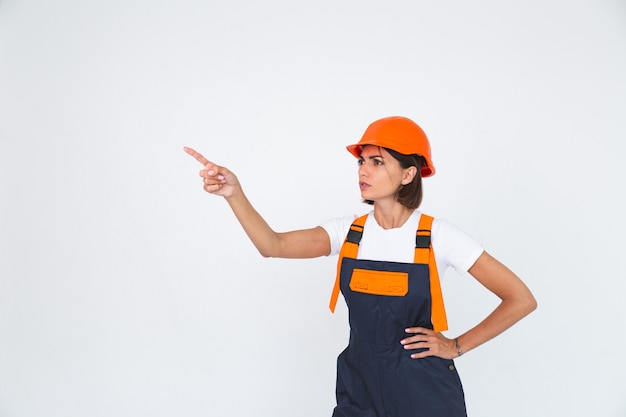 Pretty woman engineer in building protective helmet on white  angry swears at workers