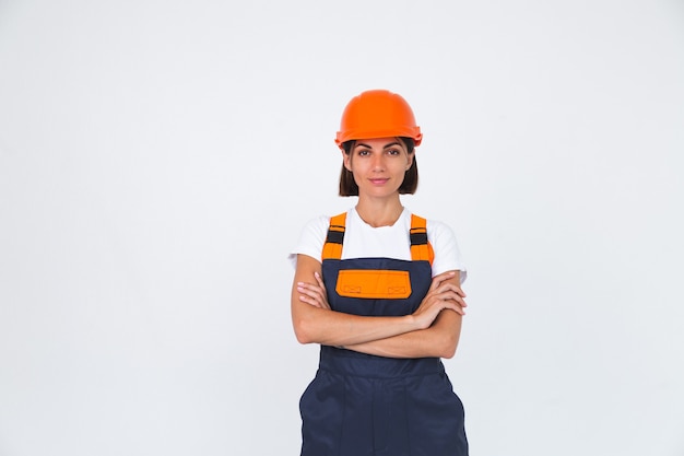 Pretty woman engineer in building protective helmet on white  confident smile crossed arms