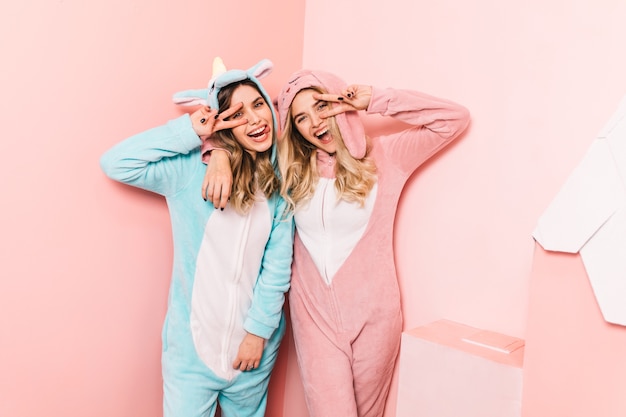 Pretty woman in funny kigurumi laughing with friend
