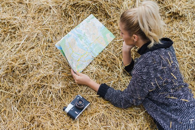 Pretty woman in hay with map