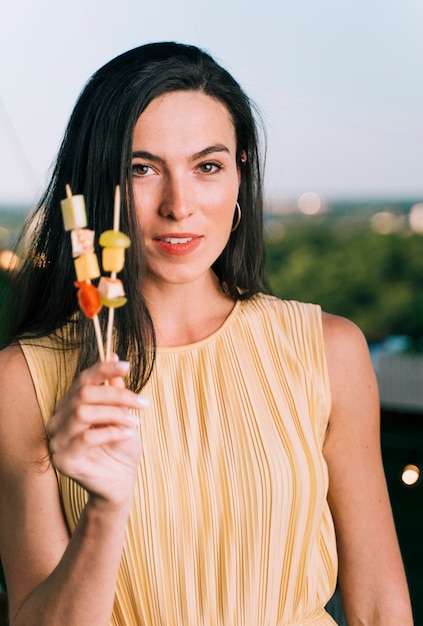 Free photo pretty woman holding appetizers with blurred background