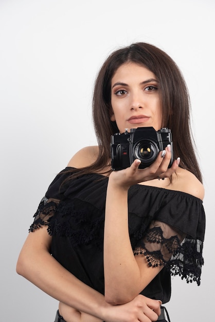 Foto gratuita fotocamera graziosa della holding della donna