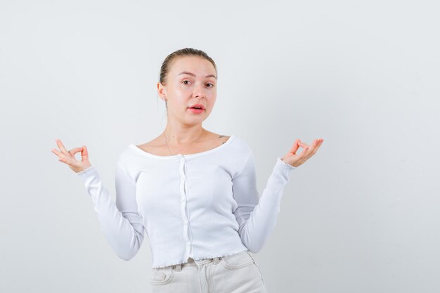 Pretty woman is showing tree with her fingers on white background