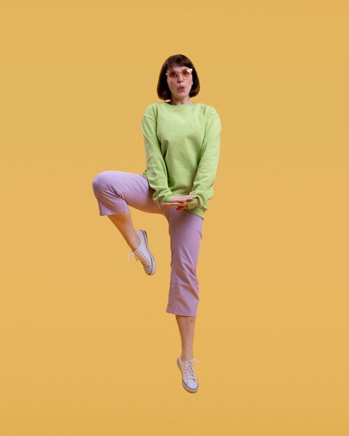 pretty woman jumping isolated on orange