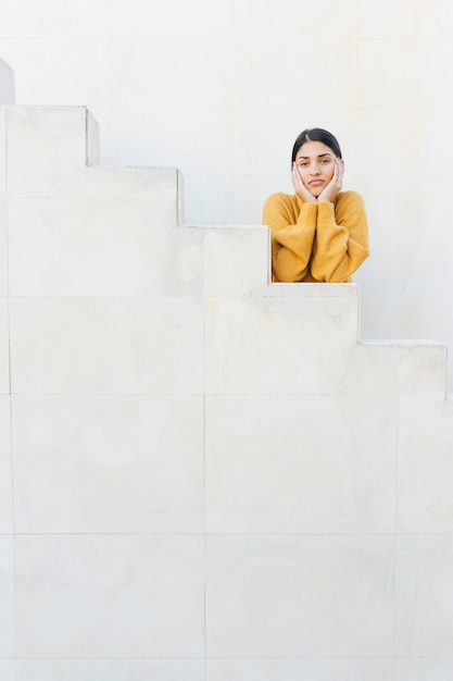 pretty woman looking at camera leaning on steps