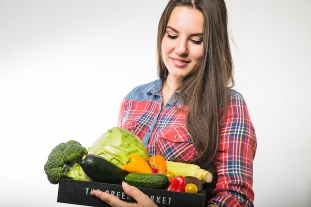 Free photo pretty woman looking at vegetables