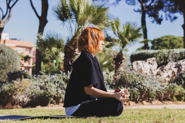 公園で瞑想する美しい女性