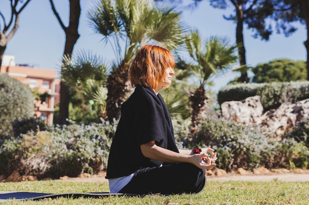 Pretty woman meditating in park