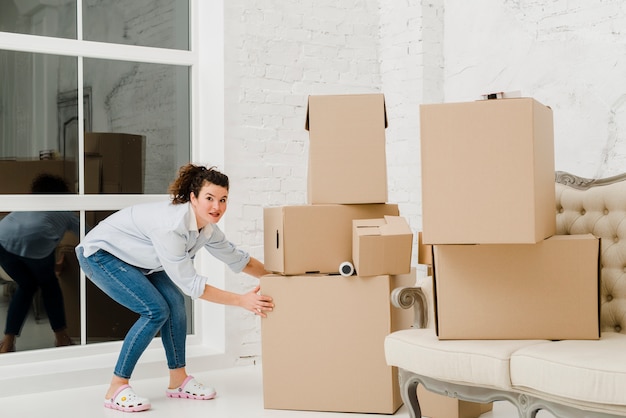 Free photo pretty woman moving boxes