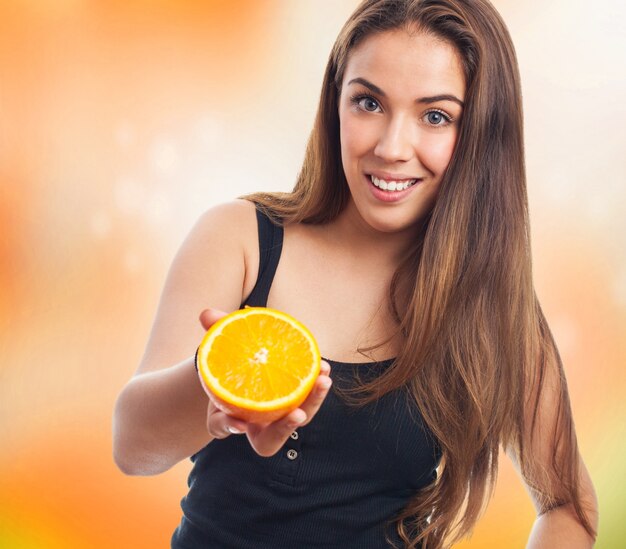 Pretty woman offering orange