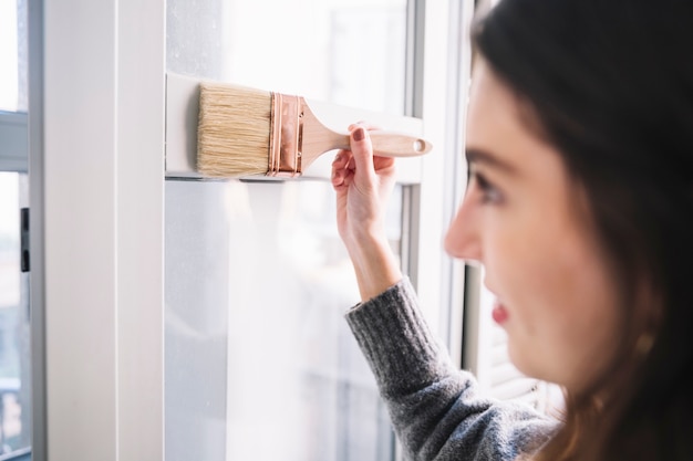 Pretty woman painting window