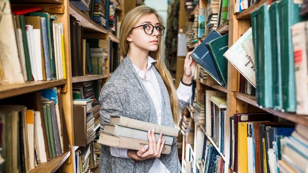 Pretty woman picking books in library