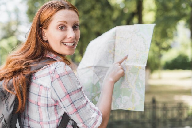 Pretty woman pointing in map