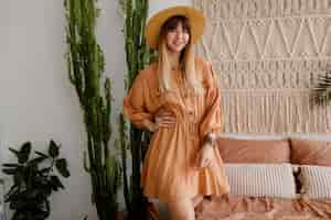 Free photo pretty woman posing in linen dress in her bedroom