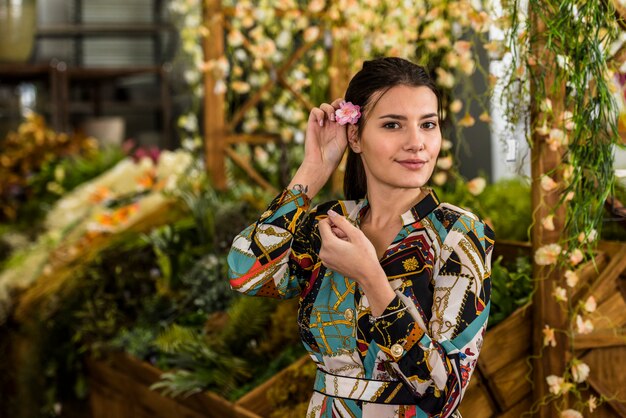 Pretty woman putting flower in hair 