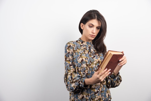 Pretty woman reading a name of the book.