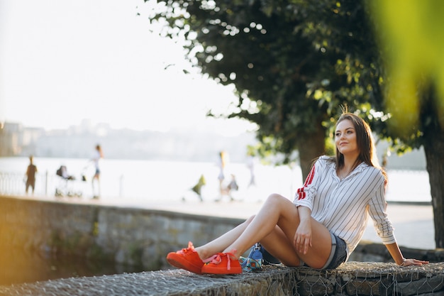 Free photo pretty woman sitting by the lake