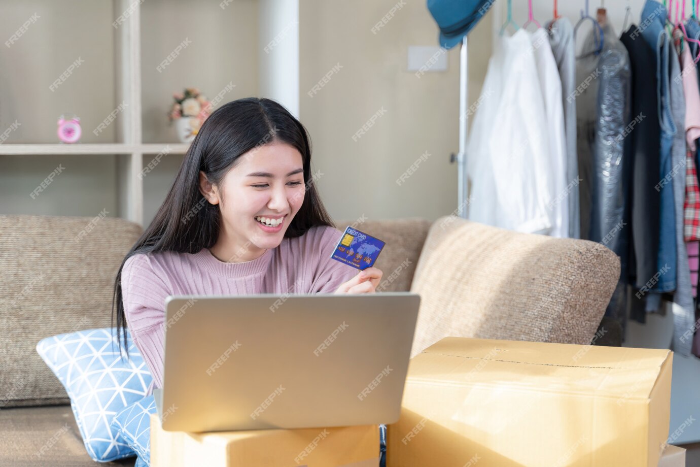 pretty woman smiling and looking to credit card in hand