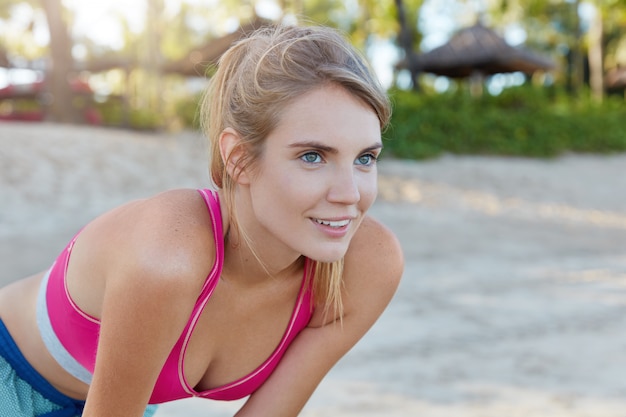 Pretty woman in sportswear on beach