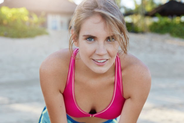 Pretty woman in sportswear on beach