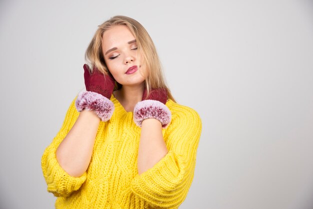 Pretty woman standing and posing in red gloves .