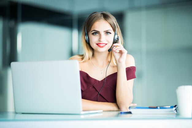 Pretty woman support center operator with headset in office