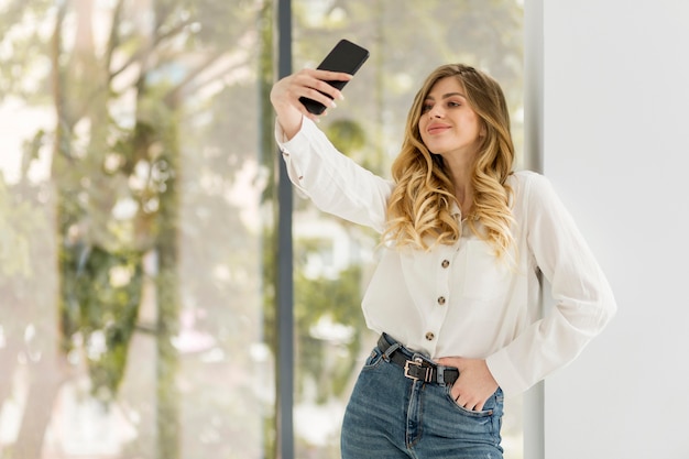 Free photo pretty woman taking selfie