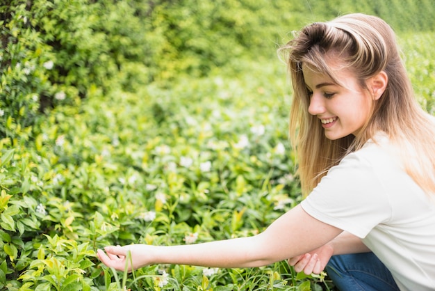 Foto gratuita fiori commoventi della donna graziosa in parco