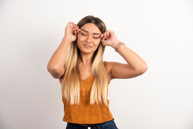 Pretty woman touching her face and posing on white background.