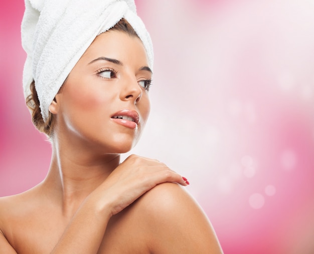 Pretty woman in towel on pink background.