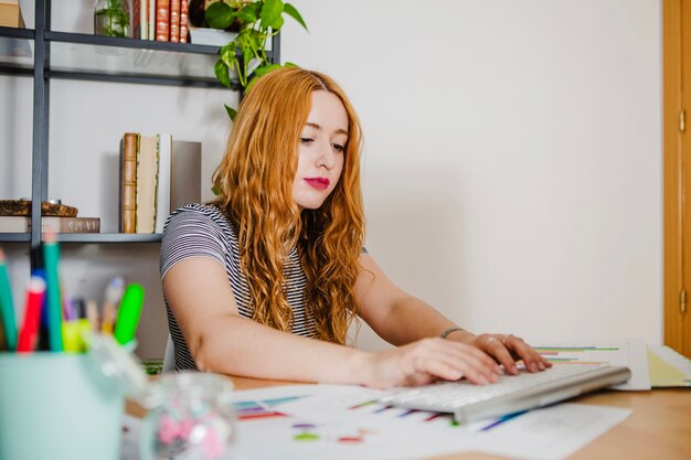 Pretty woman typing in office