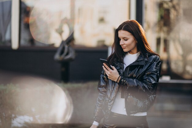 Pretty woman using phone outdoors in park