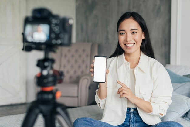 예쁜 여자 vlogging 및 그녀의 전화를 가리키는