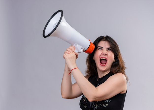 Pretty woman wearing black blouse trying to hear something from megaphone