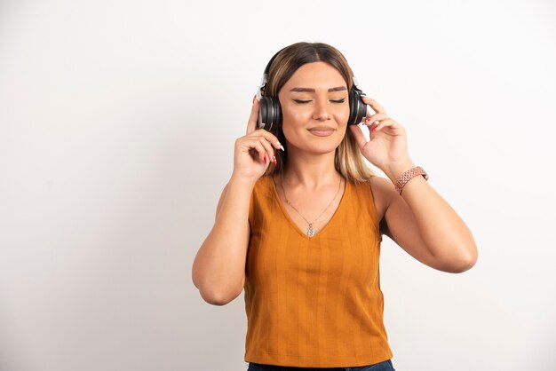 Pretty woman wearing headphones on white background.