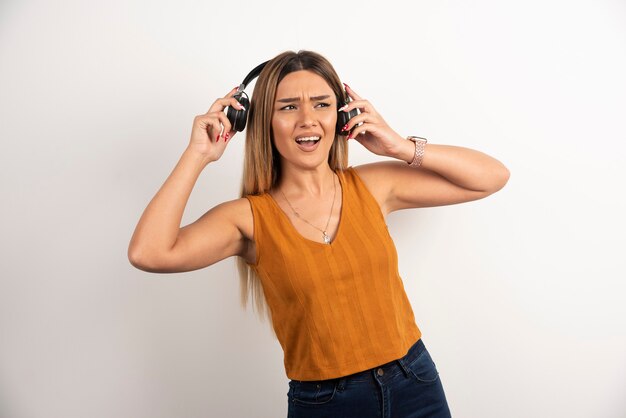 Pretty woman wearing headphones on white background.