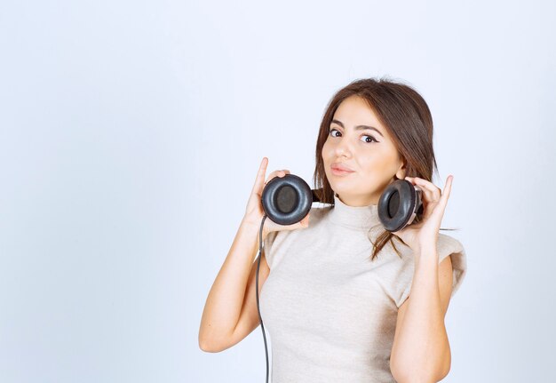 Pretty woman wearing headphones on white background .