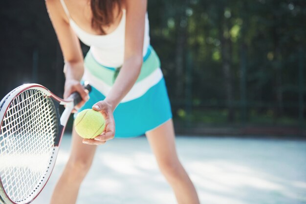 コートでスポーツウェアのテニスコートを着ているきれいな女性。