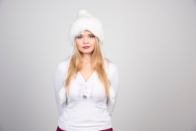 白い帽子と白いセーターのきれいな女性。