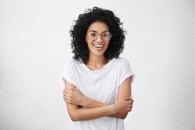 Pretty woman in white t-shirt and round eyeglasses feeling shy